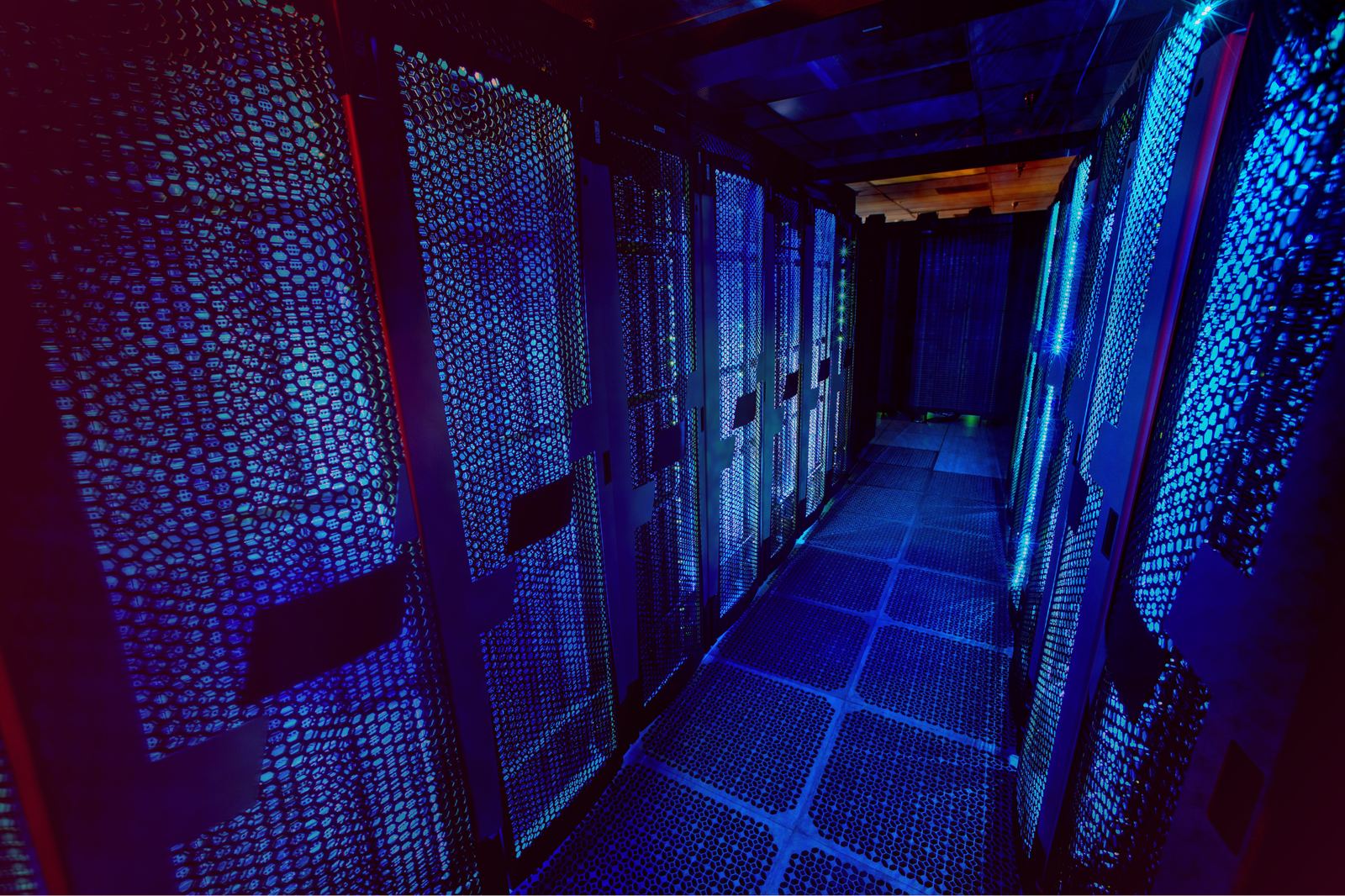 Blue-lit server rack corridor in a high-density data center